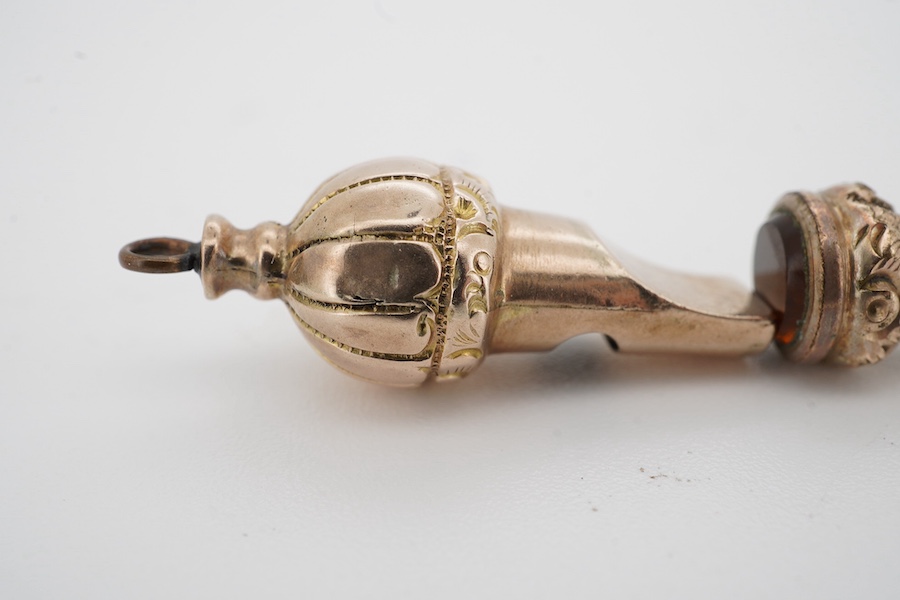 An early 20th century engraved yellow metal, citrine and turquoise set propelling pencil (turquoise stone missing), 42mm, together with a yellow metal whistle charm. Condition poor to fair